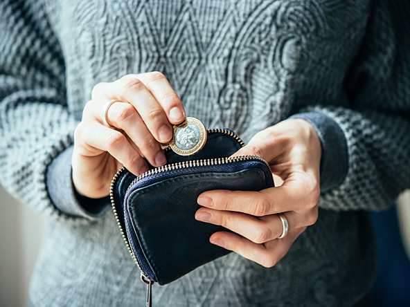 Woman putting a coin into a wallet